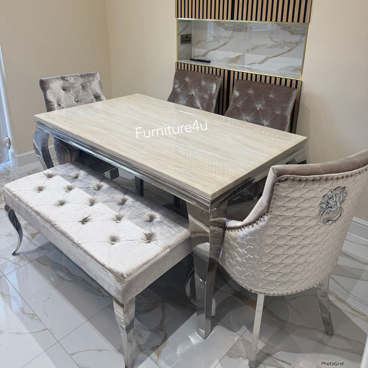 Dining room set with table, chairs, and bench in a room with a television mounted on the wall.