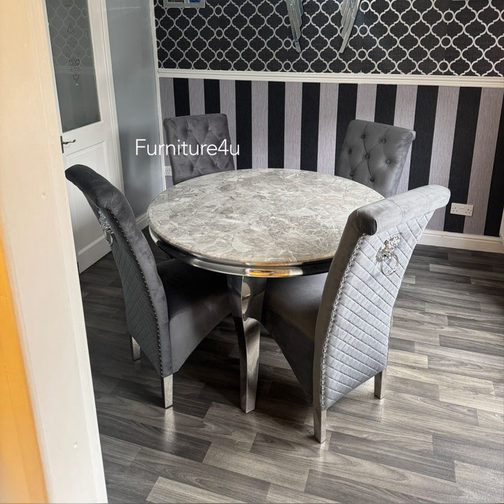 Dining room with round marble table and gray chairs against a decorative wall.