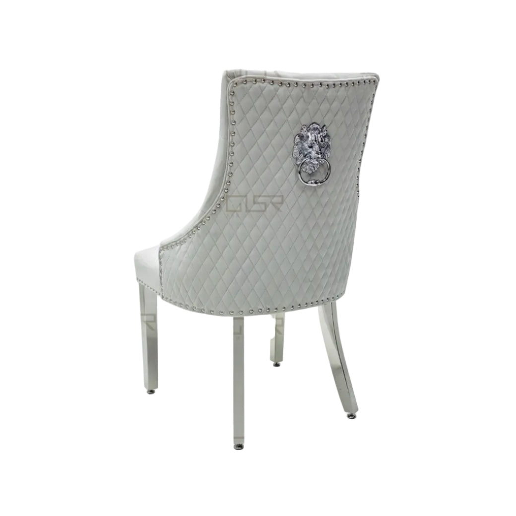 Decorative chair with quilted backrest and lion emblem on a white background