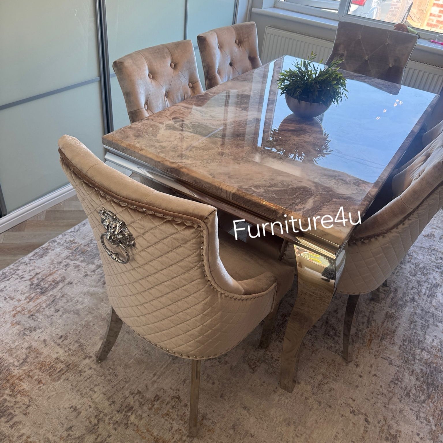 Dining table set with chairs in a room with large windows.