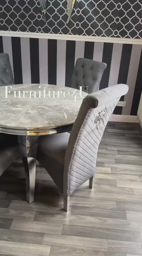 Dining room with round marble table and gray chairs against a decorative wall.